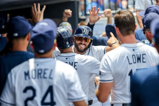 Tampa Bay Rays shortstop Jose Caballero (77) hugs designated hitter Brandon Lowe (8) after he scored on his sacrifice.