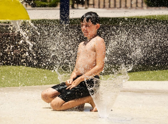 A boy plays at a splash pad at Anthem Community Park