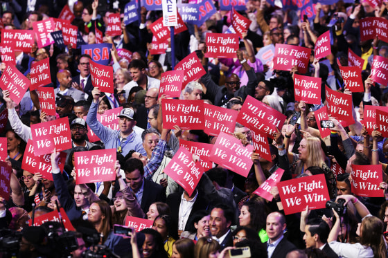 Democrats hold "We Fight, We Win" signs during the DNC