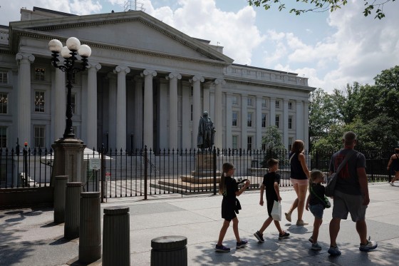 Pedestrians walk past the Treasury building in Washington, D.C.