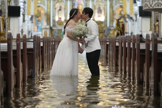 Newlyweds Jade Rick Verdillo right, and Jamaica kiss during their wedding at the flooded Barasoain church
