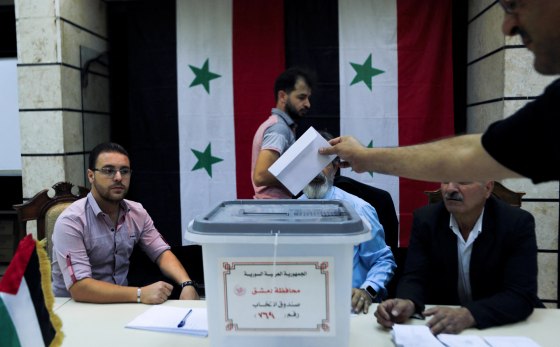 A person places an envelope in a ballot box