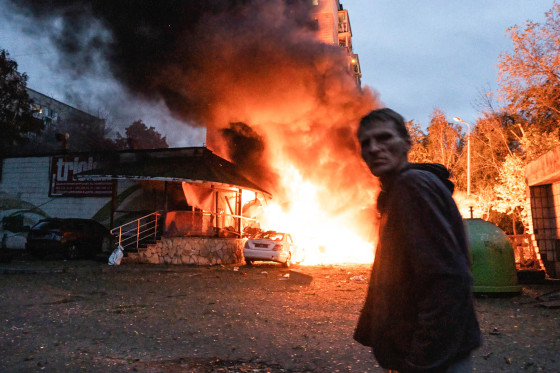 A resident walks past a fire following the Russian missile