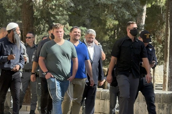 A group of people including Itamar Ben-Gvir walk through the Al-Aqsa mosque compound.
