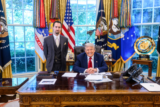 Economist E.J. Antoni stands next to President Donald Trump at his desk in the Oval Office