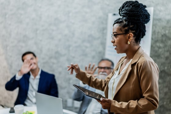 Businesswoman talking with coworkers in business meeting at office