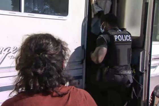 A police officer goes inside of an RV