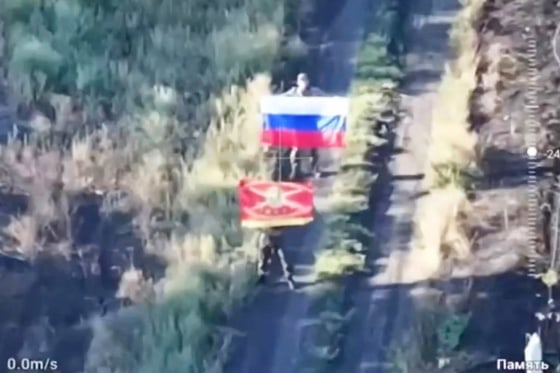 Still image from video released by Russian Defence Ministry shows Russian soldiers displaying flags, following the capture of Ukraine's settlement of Zaporizke in the Dnipropetrovsk region
