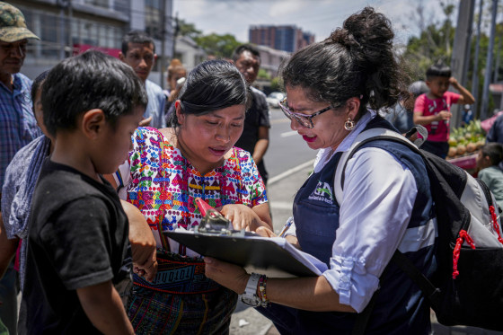 People in Guatemala check on a list.