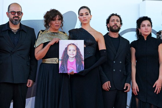 From left, standing next to one another, Amer Hlehel, Kaouther Ben Hania (holding an image of Hin Rajab), Saja Kilani, Motaz Malhees, and Clara Khoury