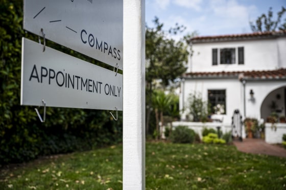 A Compass sign that reads "Compass, Appointment Only" outside of a white house