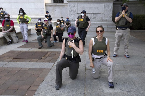 FBI officers take a knee with demonstrators as they march on Pennsylvania Ave in Washington, D.C., on June 4, 2020.
