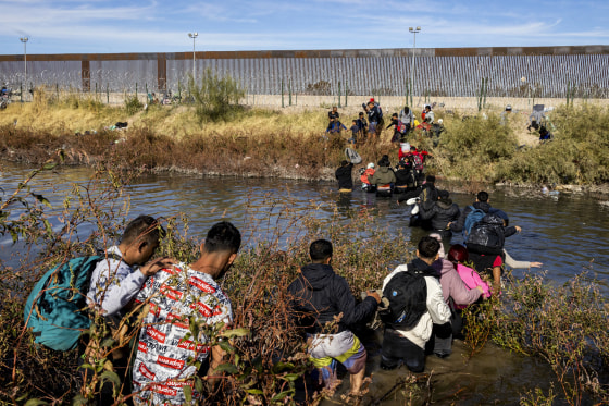 Migrants, predominantly from Venezuela, cross the Rio Grande