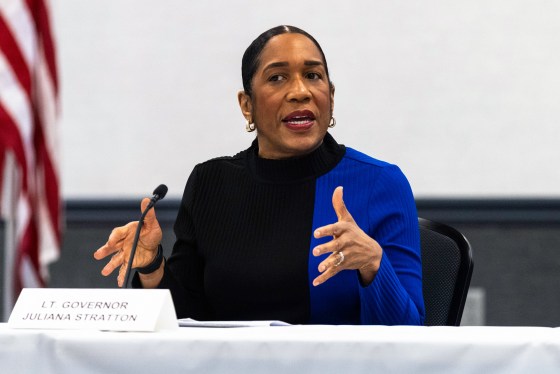 Julia Stratton speaks while seated at a table, her name plate is set in front of her