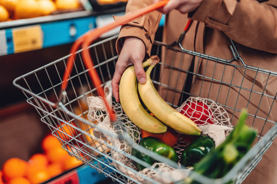Young woman shopping vegetables in supermarket