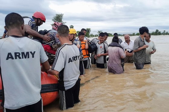 Nepalese army personnel transport survivors in a body of water