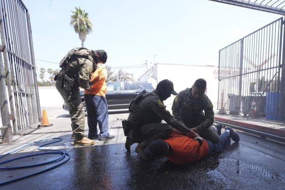 Immigration agents detain two men at a car wash on Friday, Aug. 15, 2025, in Montebello in Los Angeles County, Calif.