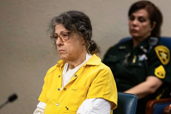 Susan Lorincz sits in court, a police officer sits behind her