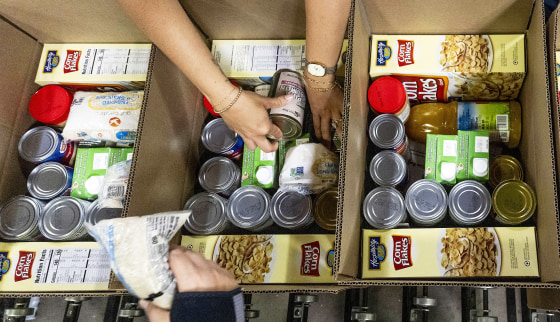 Workers pack boxes at The Orange County Food Bank.