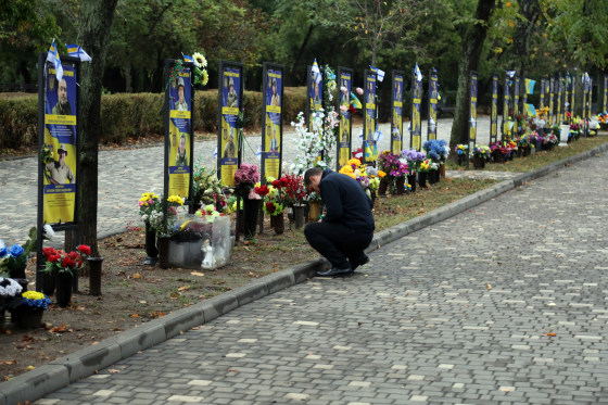 A man places a sign near the monuments with portraits and memorials of fallen Ukrainian Armed Forces on Oct. 1 in Odesa, Ukraine