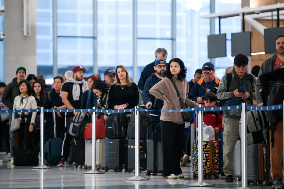 Image: People wait in a security checkpoint line at George Bush Intercontinental Airport