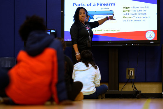 A teacher teaches about gun safety.