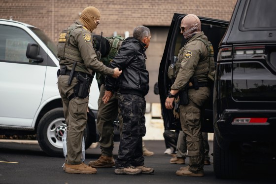 Immigration and Customs Enforcement agents take people they detained earlier to a parking lot before transferring them to an ICE facility in Chicago.