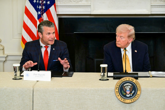 US President Donald Trump listens to Defense Secretary Pete Hegseth in the State Dining Room.
