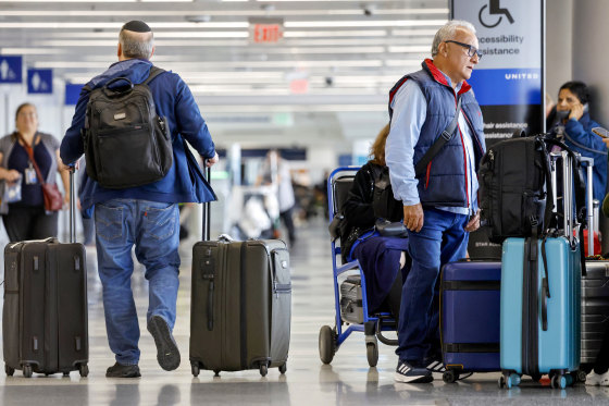 Travelers gather with their luggage.