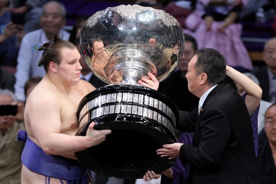 Ukrainian sumo wrestler Danylo Yavhusishyn, also known by his Japanese ring name Aonishiki Arata, receives the Prime Minister's Cup trophy after winning the Grand Sumo Tournament in Fukuoka on Nov. 23.