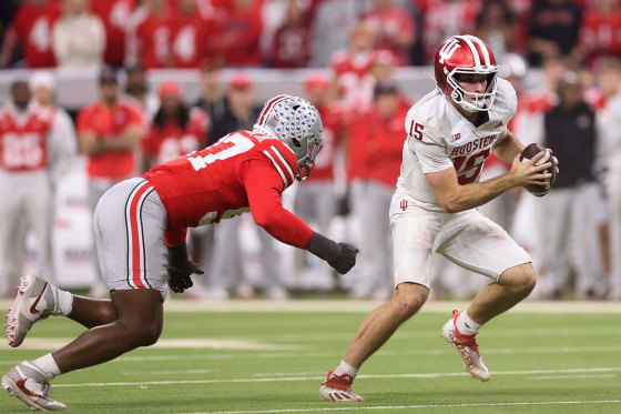 Indiana Hoosiers quarterback Fernando Mendoza scrambles under pressure from Kenyatta Jackson of the Ohio State Buckeyes