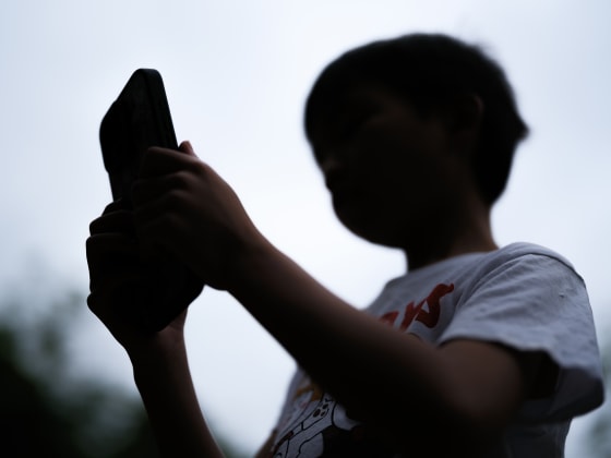A 7-year-old teenage boy looks at a phone screen on December 7 in Sydney, Australia.
