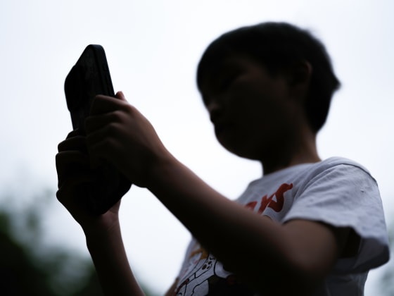 A boy uses a cellphone outside