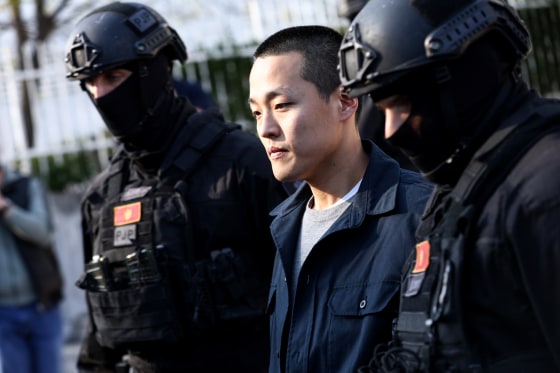 Do Kwon walks between two police officers