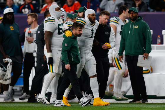 Micah Parsons of the Green Bay Packers walks off the field with a knee injury during the third quarter against the Denver Broncos.