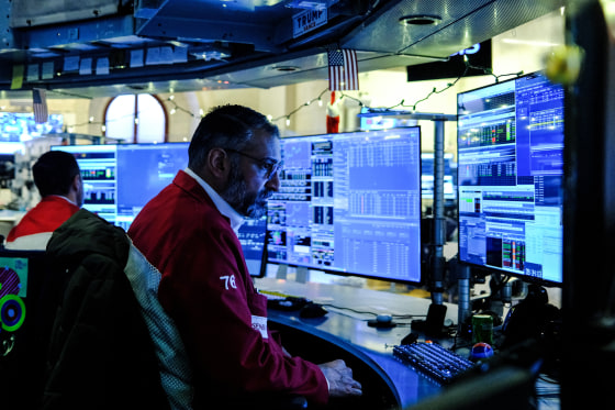 A trader looks at computer screens at his desk