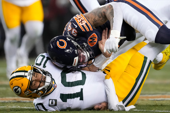 Jordan Love #10 of the Green Bay Packers is hit by Austin Booker #94 of the Chicago Bears during the first quarter at Soldier Field on December 20, 2025 in Chicago, Illinois.