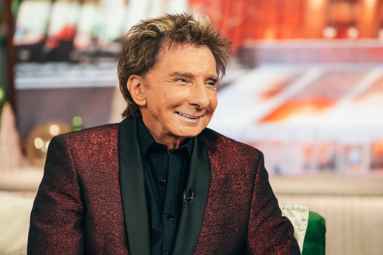 Barry Manilow smiles while seated