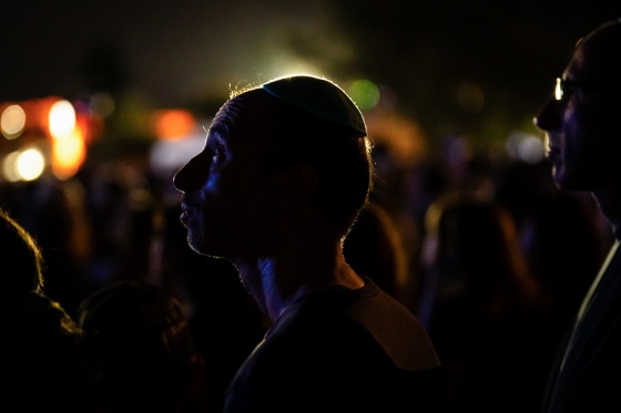 Man looks up at a candle light vigil at Bondi Pavilion.