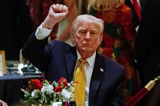 President Donald Trump pumps his fist at Christmas Eve dinner at his Mar-a-Lago club, Wednesday, Dec. 24, 2025, in Palm Beach, Fla.