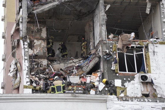 Ukrainian rescuers look through rubble inside a damaged residential building following Russian drones and missiles attack, in Kyiv, on Dec. 27.