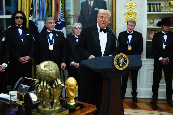 President Donald Trump delivers remarks as honorees (L-R) musician Gene Simmons of the rock band KISS, actor Sylvester Stallone, musician Peter Criss of the rock band KISS, actor Michael Crawford and country musician George Strait look on during the medal presentation ceremony for the 2025 Kennedy Center Honorees in the Oval Office of the White House on December 06, 2025 in Washington, DC.