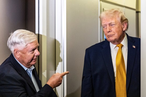 Donald Trump, right, and Lindsey Graham stand near each other on a plane