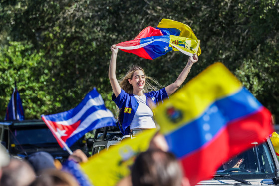 People wave Venezuelan flags outside