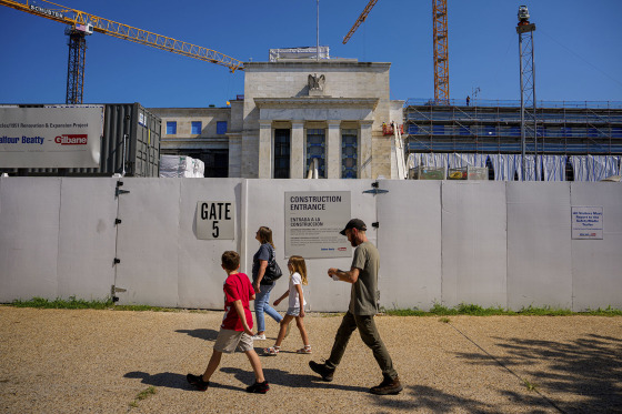 Pedestrians walk past the Marriner S. Eccles Federal Reserve Board Building during renovation on July 24, 2025.