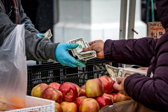 A shopper pays for produce at the farmer's market 