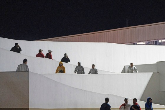 Migrants walk into Mexico after being deported from the U.S. at El Chaparral pedestrian border bridge in Tijuana, Mexico