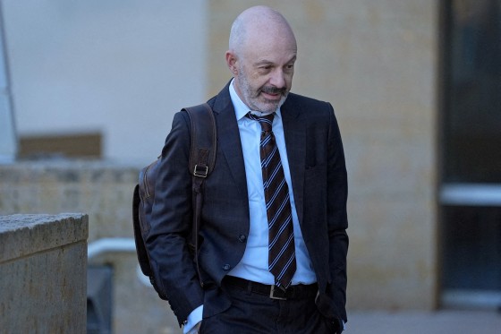 Tom Goldstein arrives for jury selection in his trial at the U.S. District Court in a suit and tie.