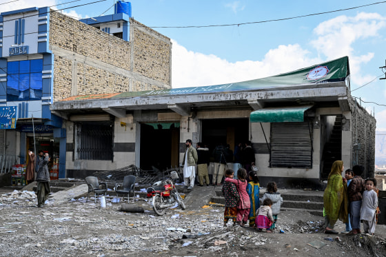 Local residents look at a damaged bank on the outskirts of Quetta on Sunday, a day after an attack by Baloch separatists.
