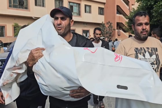 Rami Essam Abu Jamea and his family members cry while kneeling on the floor